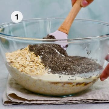 Mezcla de avena con chía, yogur, leche vegetal y miel en un bowl de vidrio, siendo removida con espátula para preparar avena trasnochada cremosa.