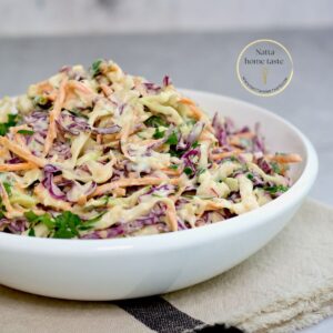 ensalada de repollo y zanahoria con mayonesa en un bol blanco sobre una mesa