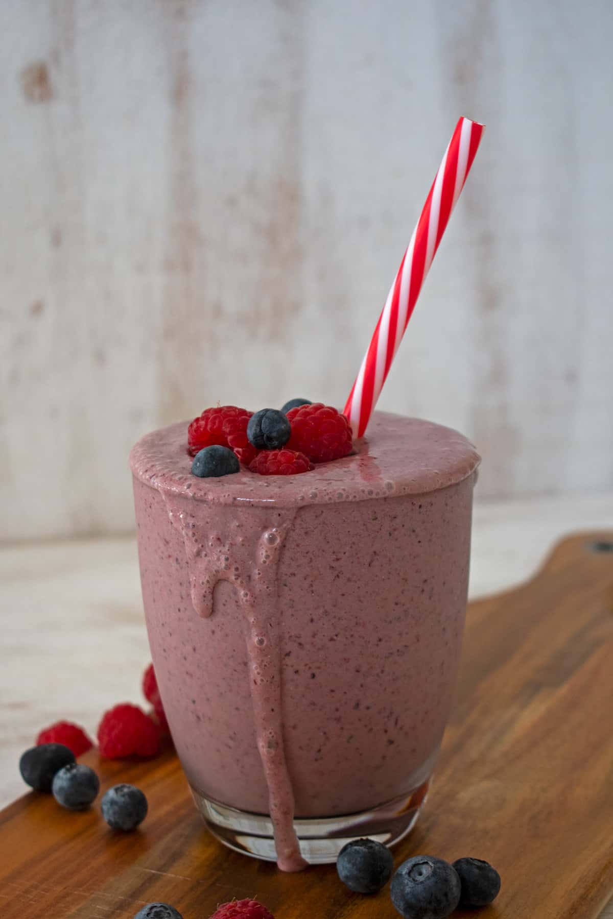 smoothie de frutos rojos con un pitillo rojo y blanco