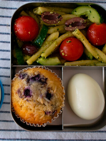 lonchera con ensalada de pasta, muffin, huevo duro y uvas