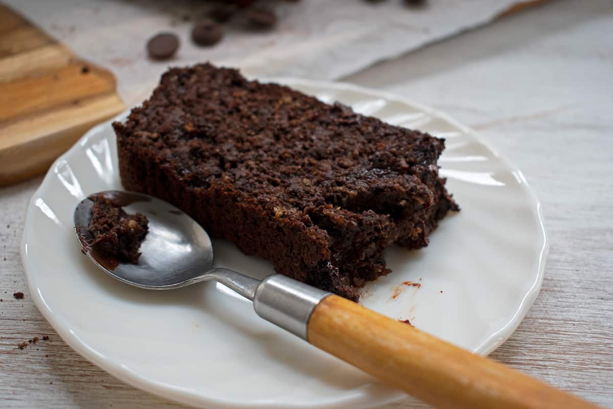 porción de pan de chocolate y banana sin azúcar servida en un plato blanco con una cuchara