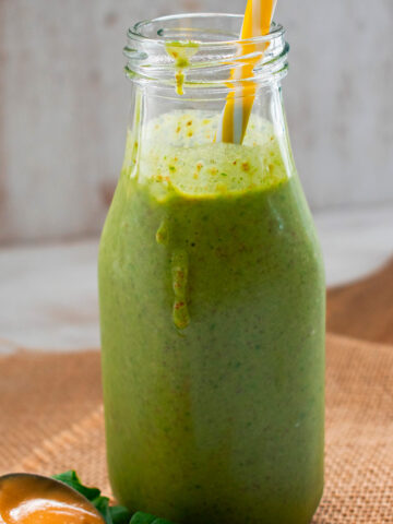 smoothie verde servido con una cuchara de mantequilla de maní