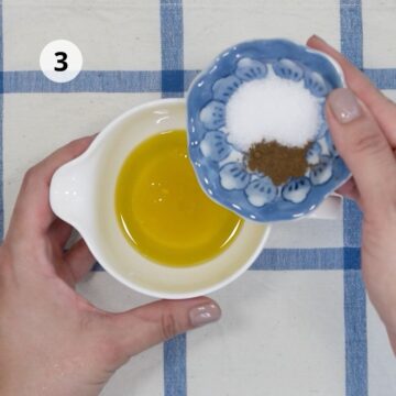 Imagen desde arriba. recipiente pequeño blanco con aceite de oliva y sal y pimienta.