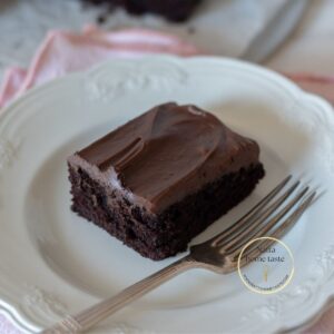 Bizcocho de chocolate sin huevo en un plato blanco con un tenedor al lado.