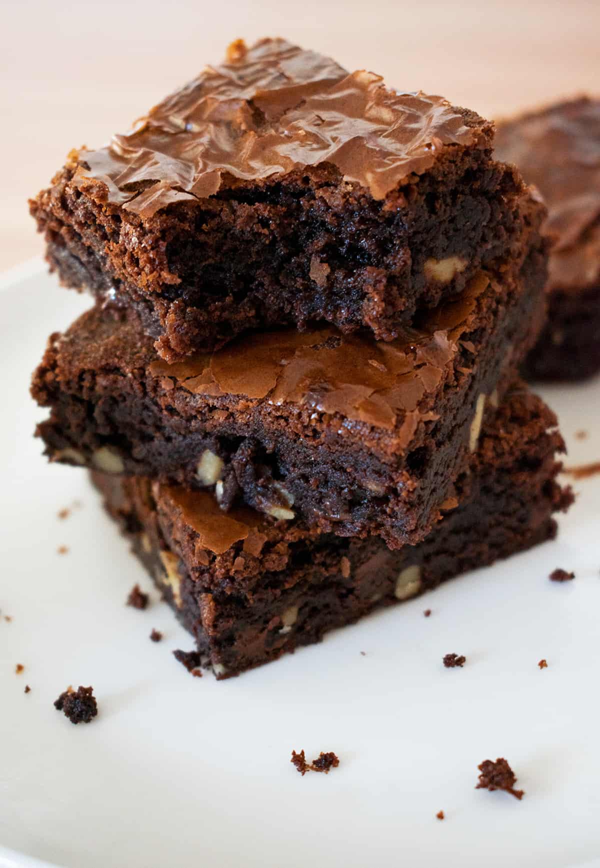 tres brownies caseros uno sobre otro sobre una mesa blanca.