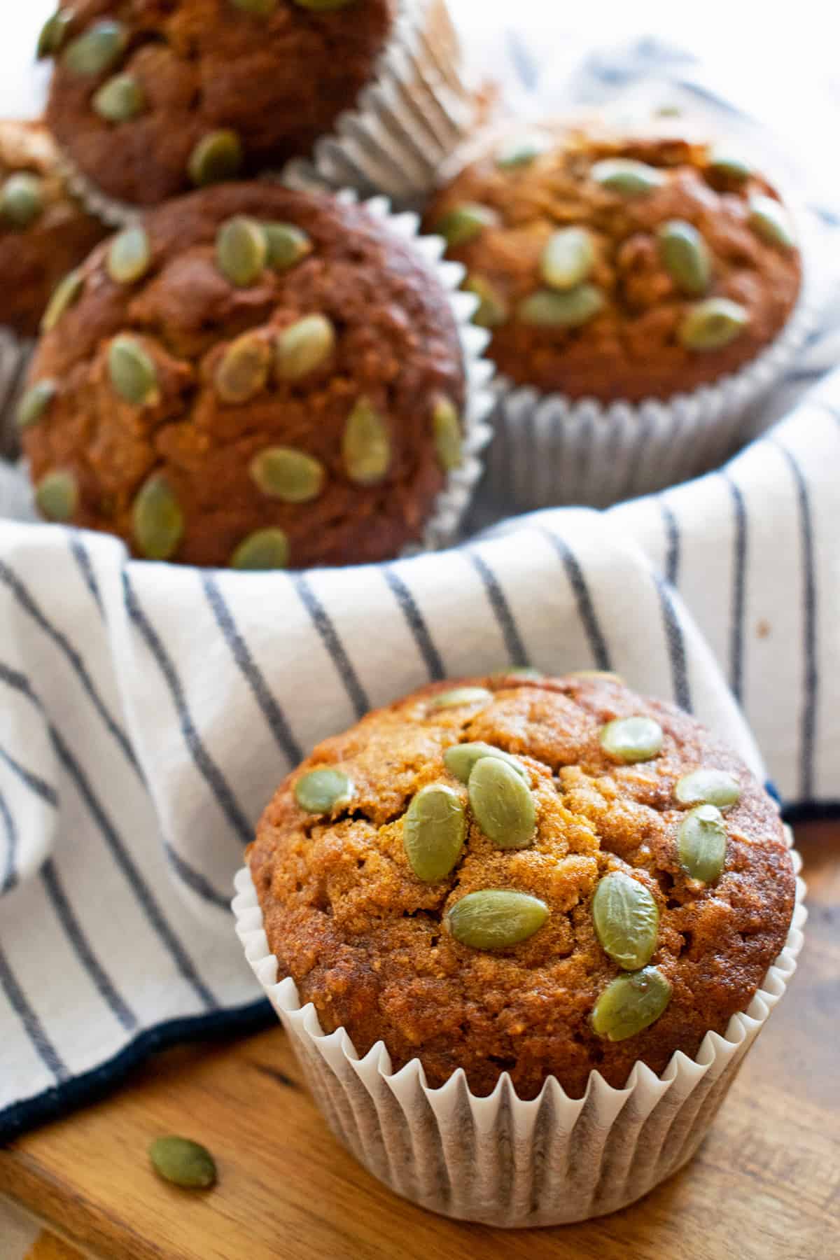 Muffins de calabaza y avena sobre un paño blanco con lineas azules.