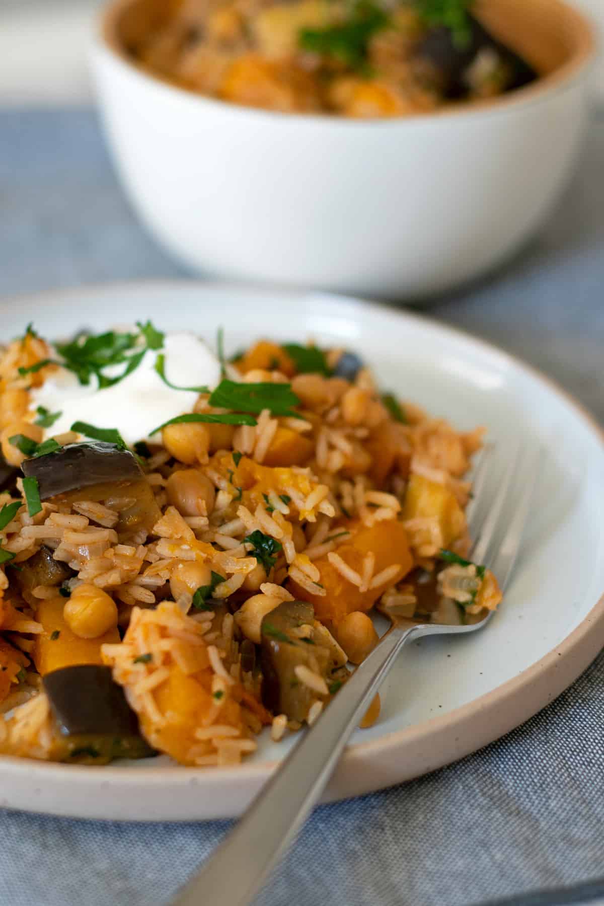 arroz con garbanzos y verduras servido en un plato redondo con un tenedor