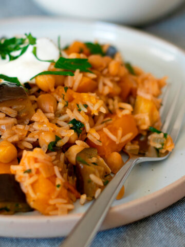 arroz con garbanzos servido en un plato redondo con un tenedor