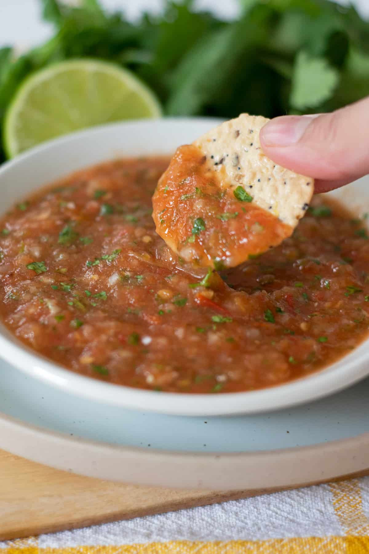 haciendo dip en una salsa con un chip de maíz 