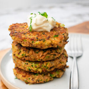 croquetas de quinoa y atún servidas una sobre otra servidas sobre un plato blanco.