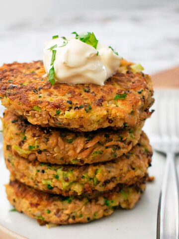 croquetas de quinoa y atún servidas una sobre otra servidas sobre un plato blanco.