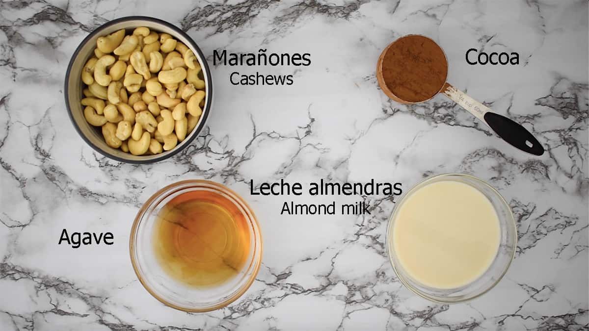 ingredientes para preparar crema de cacao vegana. marañones, cocoa, agave y leche de almendras