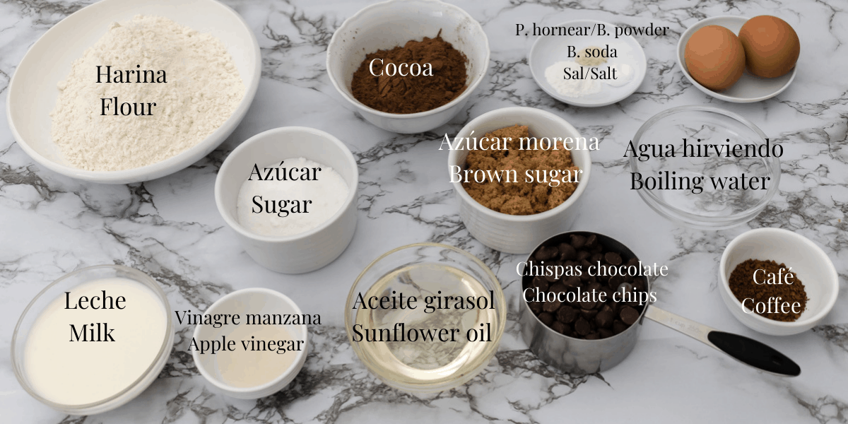 Ingredientes para preparar muffins de chocolate. Harina de trigo, cocoa, azúcar blanca y azúcar morena, café, aceite de girasol, leche, vinagre de manzana, aceite de girasol, chispas de chocolate, huevos, polvo de hornear, sal y bicarbonato de soda.