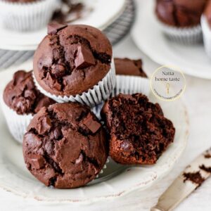 muffins de chocolate servidos en un plato redondo sobre una mesa blanca.