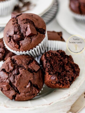 muffins de chocolate servidos en un plato redondo sobre una mesa blanca.