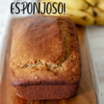 pan de banana servido sobre una tabla de madera con bananos frescos en la parte de atrás