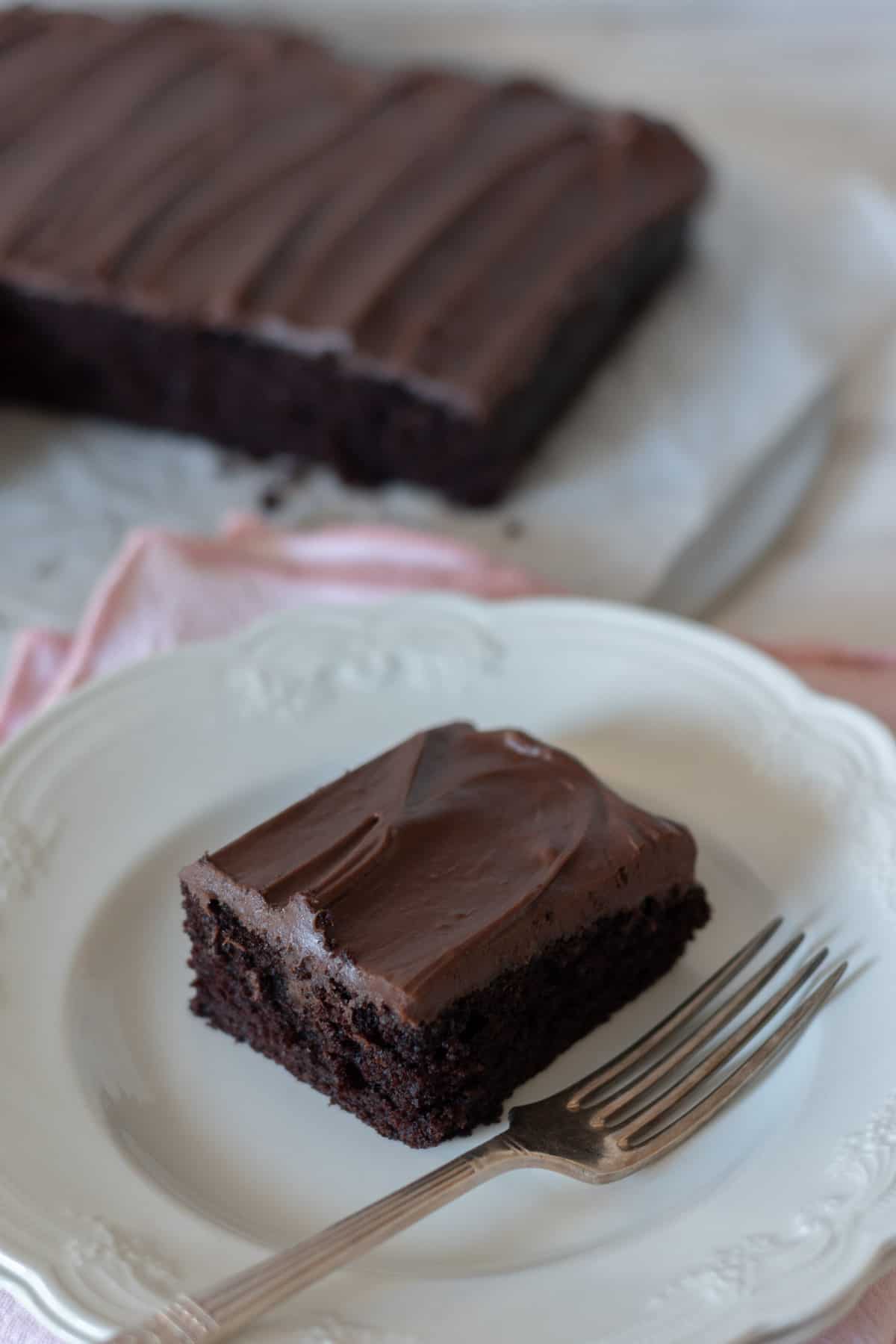 Bizcocho de chocolate sin huevo en un plato blanco con un tenedor al lado.