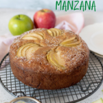 torta de manzana sobre una parrilla con dos manzanas atrás