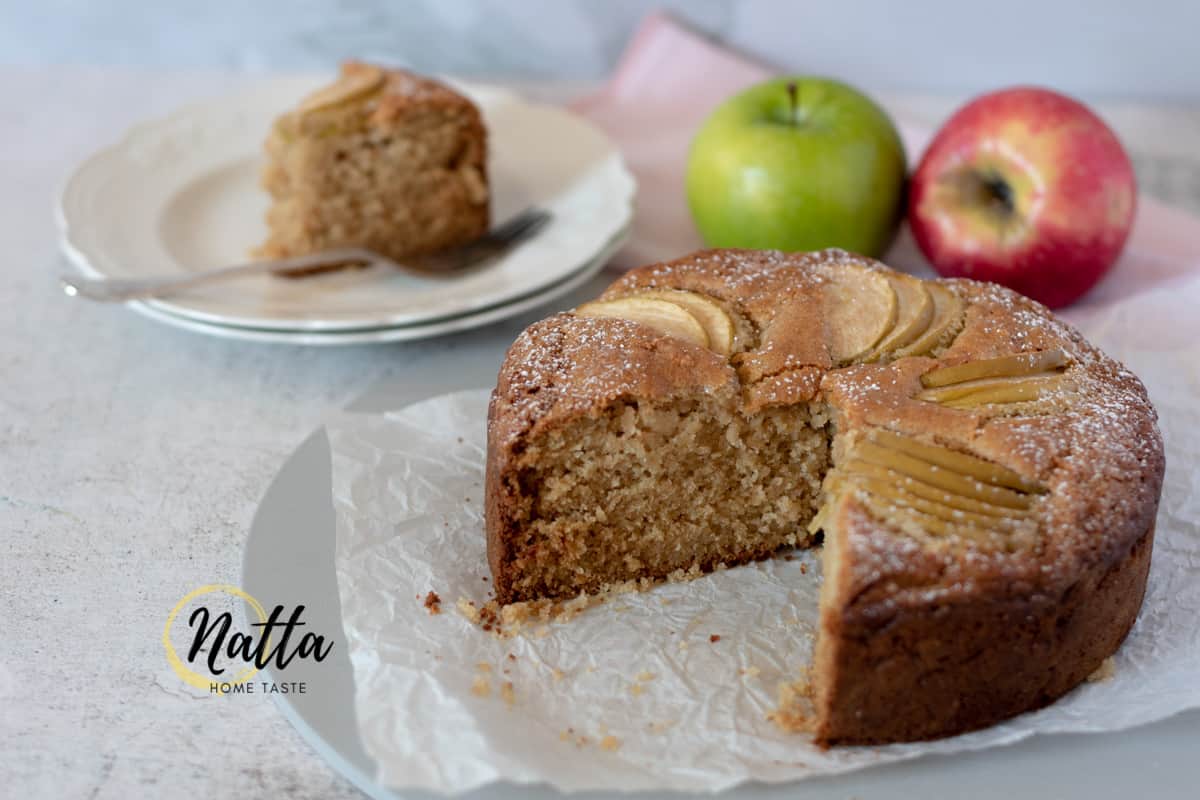 pastel de manzana verde sobre una mesa blanca con dos manzanas atrás 