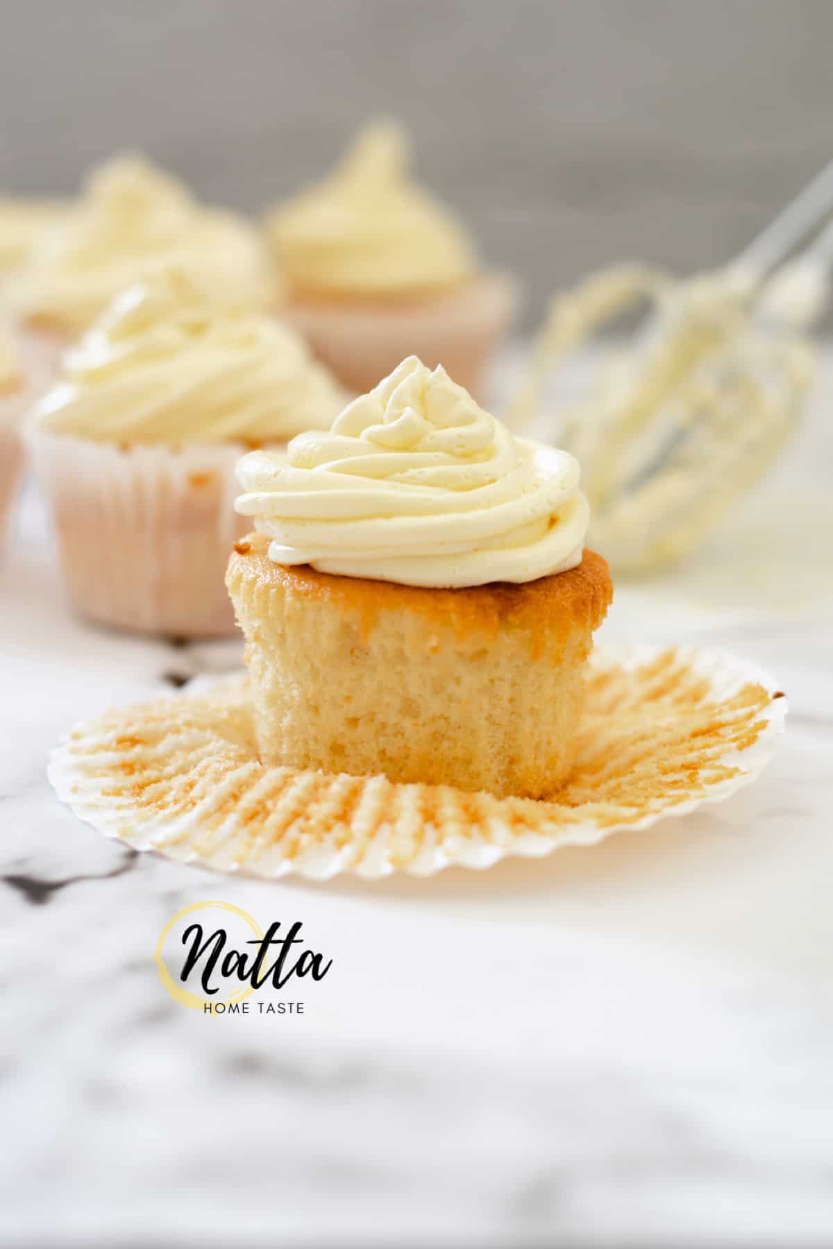 cupcakes de vainilla con crema de mantequilla sobre una mesa de mármol.