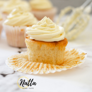 cupcakes de vainilla con crema de mantequilla sobre una mesa de mármol