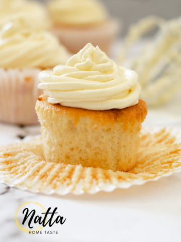cupcakes de vainilla con crema de mantequilla sobre una mesa de mármol