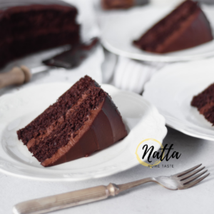 Torta de chocolate servida en platos blancos con un tenedor plateado.