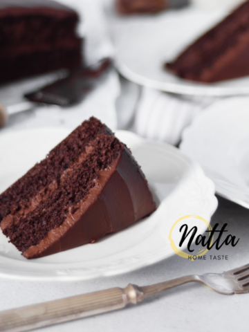 Torta de chocolate servida en platos blancos con un tenedor plateado.