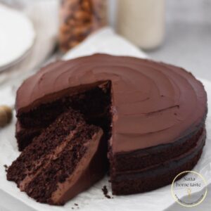 Torta de chocolate servida en platos blancos con un tenedor plateado.