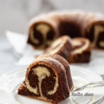 Porción de bizcocho marmolado de vainilla y chocolate servida sobre un plato blanco