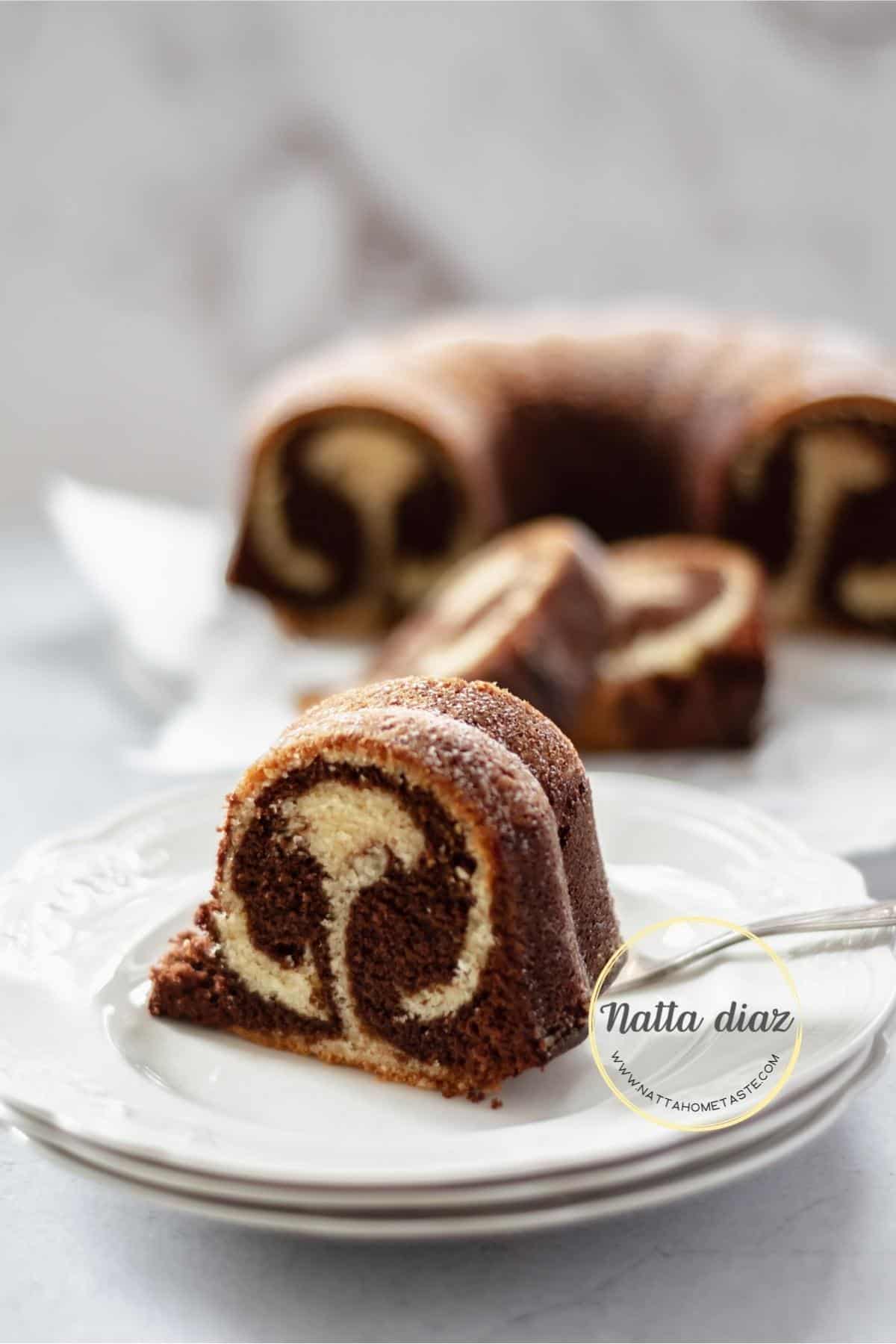 Una porción de bizcocho marmolado de vainilla y chocolate servido en un plato blanco.