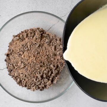 trozos de chocolate oscuro en un bol transparente. crema de leche caliente en una olla lista para mezclar para hacer ganache de chocolate.