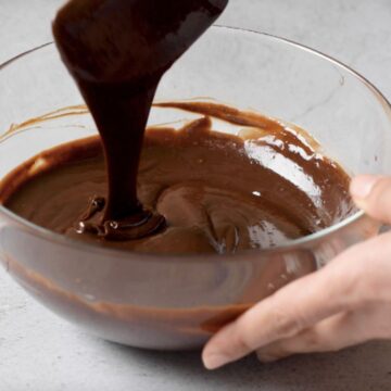 Ganache de chocolate brillante y caliente acabado de hacer en un bol transparente.