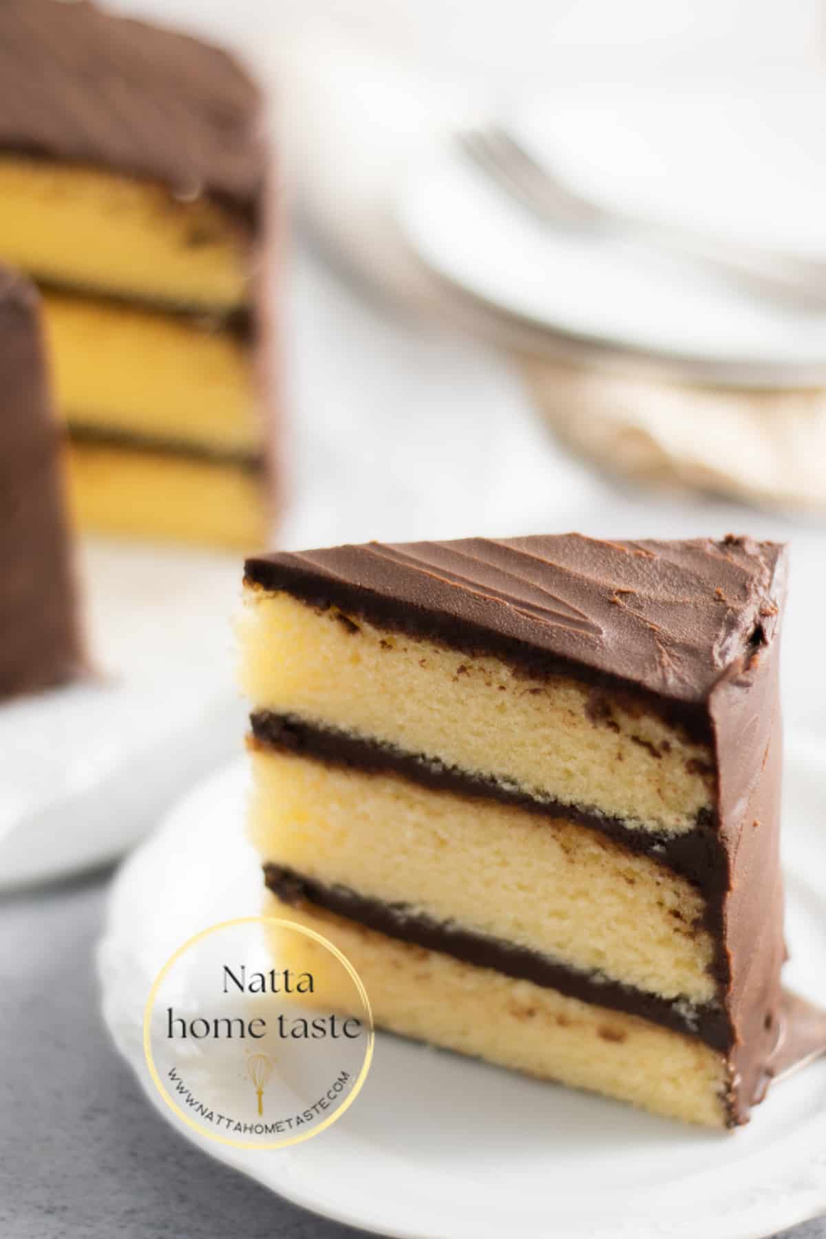 torta de vainilla con ganache de chocolate servida en un plato blanco.