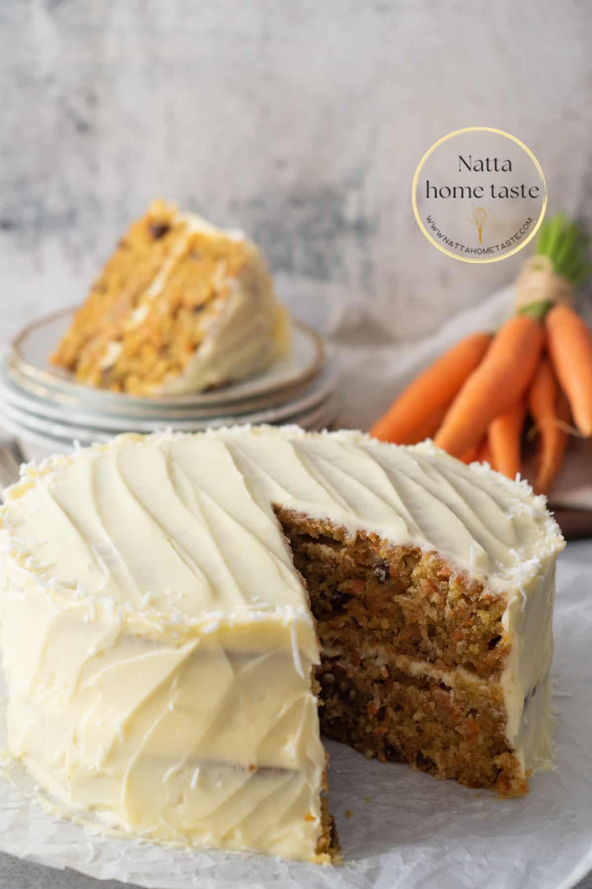 Torta de zanahoria casera de dos capas con frosting de queso crema. Zanahorias pequeñas en la parte de atrás con una porción de pastel servida sobre unos platos pequeños.