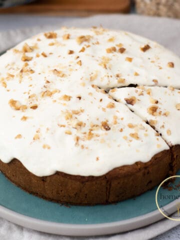 Torta de zanahoria redonda con glaseado de yogur griego y nueces servida en un plato redondo