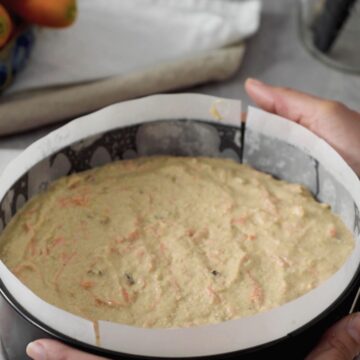 masa de pastel de zanahoria saludable con avena y canela en un molde redondo listo para llevar al horno.