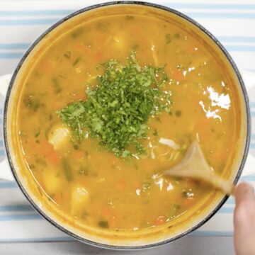 Olla con sopa de pasta colombiana y cilantro fresco por encima.