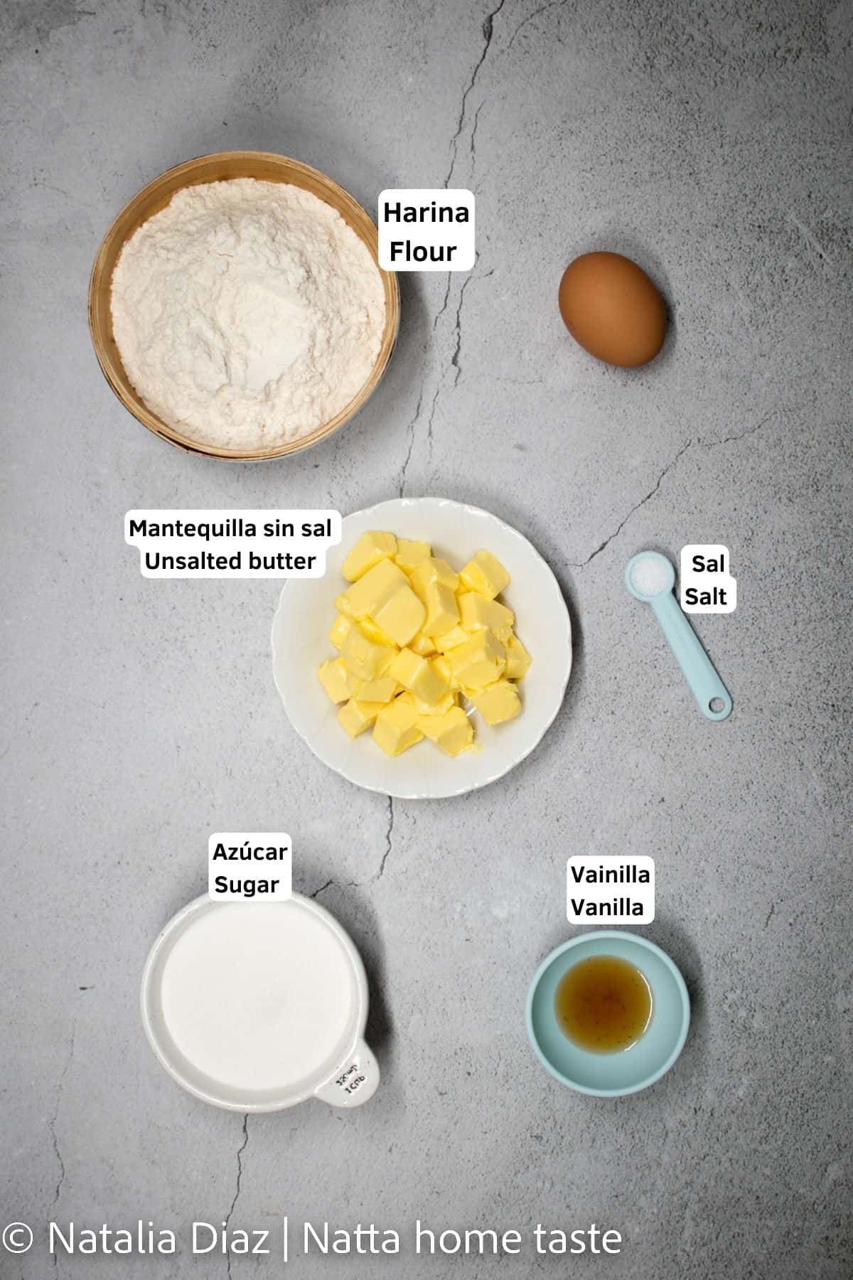 ingredientes para preparar galletas de mantequilla en contenedores pequeños. Harina, mantequilla, huevo, azúcar, vainilla, sal.