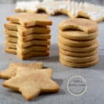 galletas de mantequilla en forma de estrellas y círculos una sobre otra sobre una mesa.