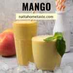 dos vasos de vidrio uno más alto que el otro con batido de mango con un mango fresco entero en la parte de atrás y un vaso con pitillos de papel.