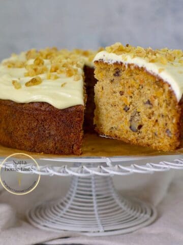 Carrot cake sin gluten sobre un soporte para pasteles blanco