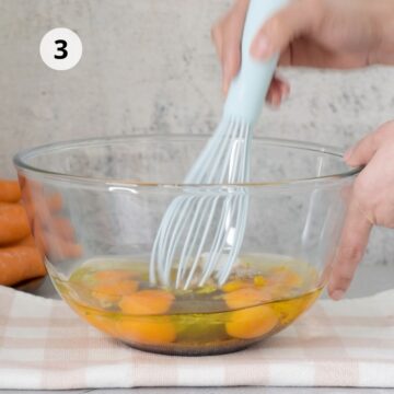 tazón de vidrio con huevos, aceite y azúcar y un batidor de mano 