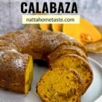 budín de calabaza redondo sobre un plato blanco con rodajas de calabaza fresca en la parte de atrás