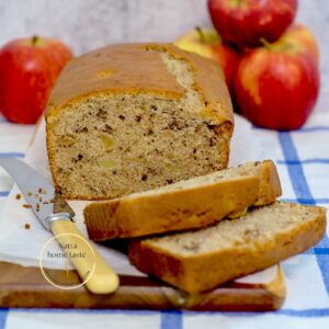 bizcocho de manzana sobre una tabla con manzanas rojas atrás