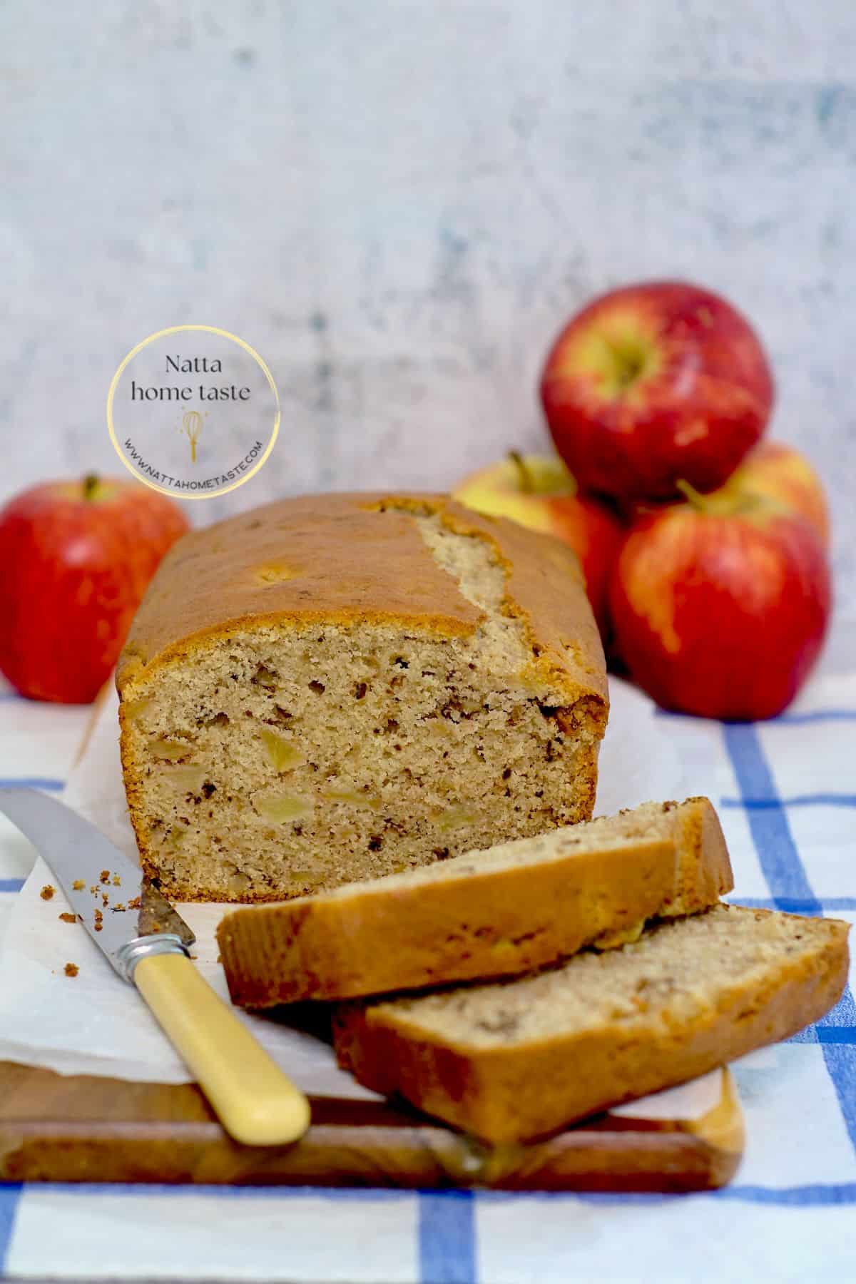 bizcocho de manzana sobre una tabla con manzanas rojas atrás