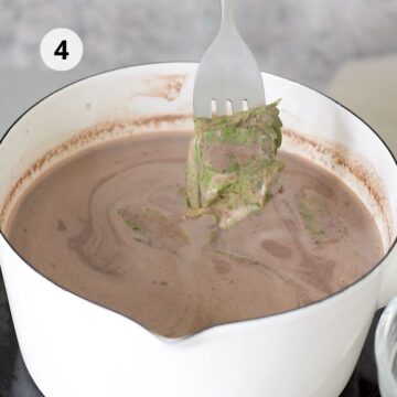 olla blanca con mezcla de leche y hojas de menta fresca