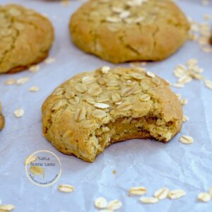 galletas de avena caseras sobre un papel blanco de hornear con copos de avena al rededor