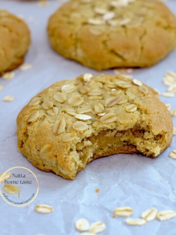 galletas de avena caseras sobre un papel blanco de hornear con copos de avena al rededor