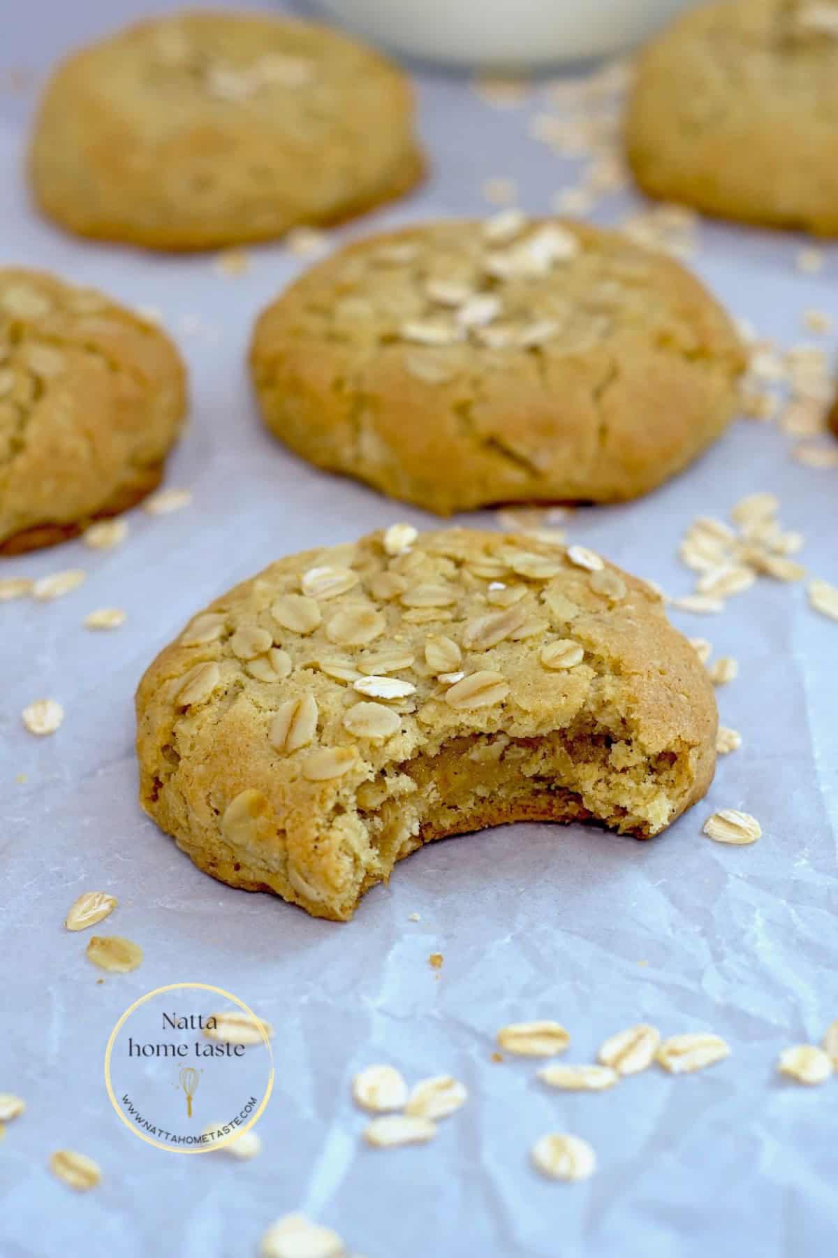 galletas de avena caseras sobre un papel blanco de hornear con copos de avena al rededor